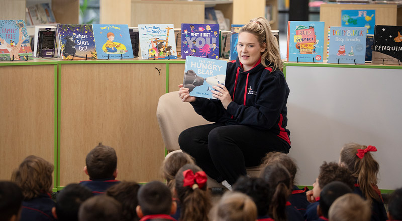 Teacher reading to students in the library at St John XXIII College Stanhope Gardens